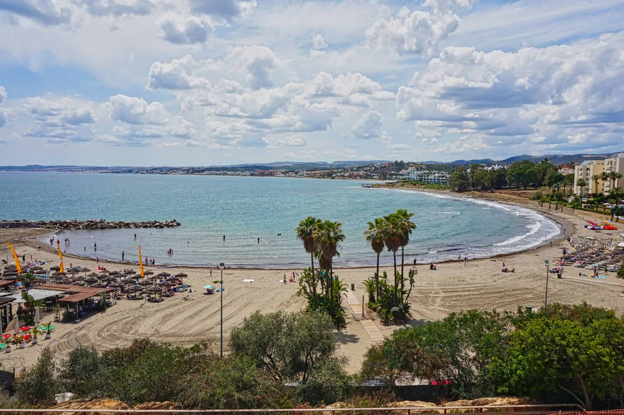 Uitzicht op het strand en de boulevard in Estepona met palmbomen en zee.